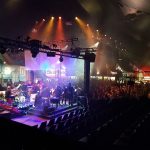 Blick von hinten auf die Bühne mit der SZ-Band Deadline. Im Hintergrund sieht man ein volles Zelt.