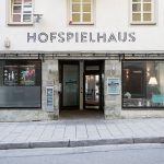 Häuserfront des Hofspielhauses. Darüber der gleichnamige Schriftzug in schwarzen Lettern.