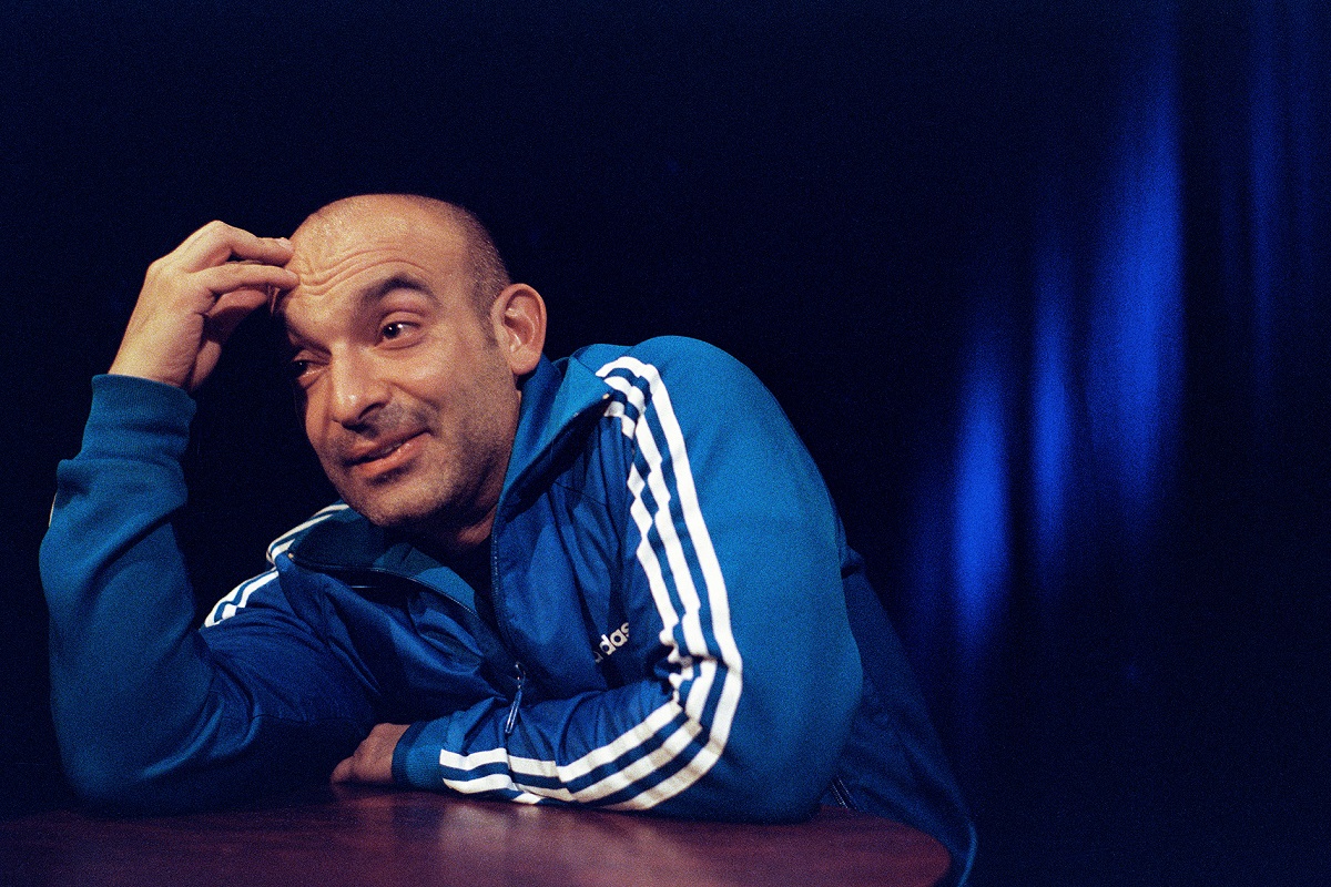 Kabarettist Django Asül lehnt auf einem Stehttisch und denkt nach