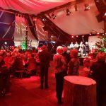 Senioren sitzen im Live-Musikzelt des Wintertollwoods und eine Band spielt