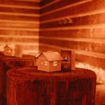 Deine Tollwood Weihnachtsfeier 2020 mit beleuchteten kleine Hexenhäuschen als Dekoration auf Stehtischen aus Holzstämmen