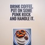 zu sehen ist ein Sticker der an einer weißen Tür klebt. Motiv vom Sticker ist ein bayrisches Weißwurst Frühstück auf einem Teller und darüber einen Spruch der auf Englisch etwas mit Punk rock und Kaffee zutun hat