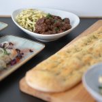 Zu sehen ist ein Auszug aus dem Bio-Buffet, welches 2024 im Hexenkessel für Weihnachtsfeiern über die Eventagentur vollblut LiveMarketing gebucht werden kann: Beetroot Burratina, Bacon-Frühlingslauch-Creme, hausgemachte Focaccia, Aprikosen-Rosmarin-Creme