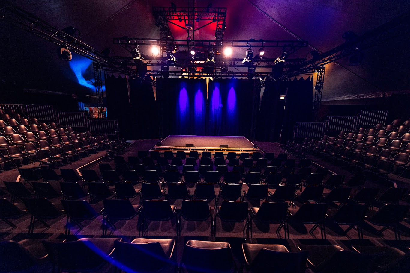 Das Bild ist ein Beispielbild für unser Jobangebot "Logistiker*in Betriebsversammlung" und zeigt die Bühne und Stuhlreihen des Weltsalons.